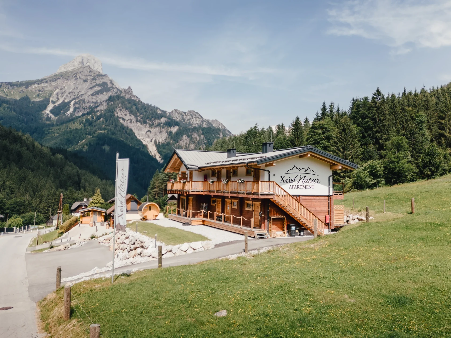 Xeis Naturapartments mit Holzbalkon vor den Bergen des Gesäuses in Johnsbach